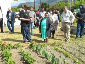 Local resident Sarah Brand shows Minister Meyer her food garden