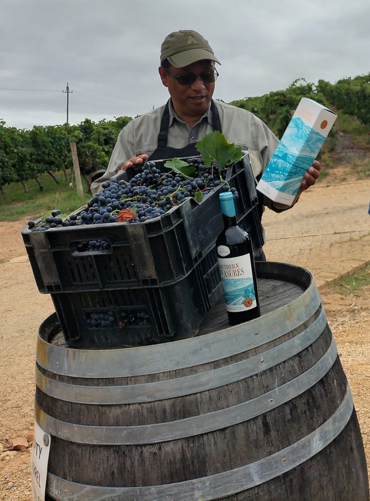 Minister Meyer holds a bottle of the award winning pinotage